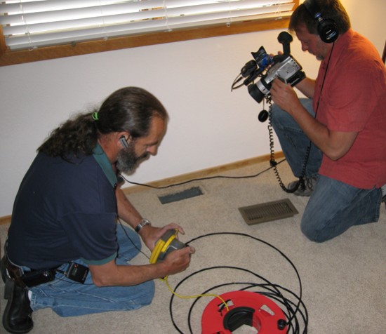Nick Gromicko films CMI Hank Valenzano as he prepares to inspect a duct.