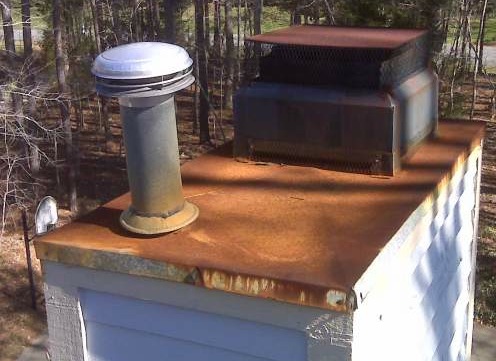 A rusted roof with a rusted chimney vent